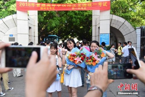 资料图:2018年高考结束,家长为刚刚走出考场的孩子拍照留念。 王以照 摄  资料图:2018年高考结束,家长为刚刚走出考场的孩子拍照留念。 王以照 摄